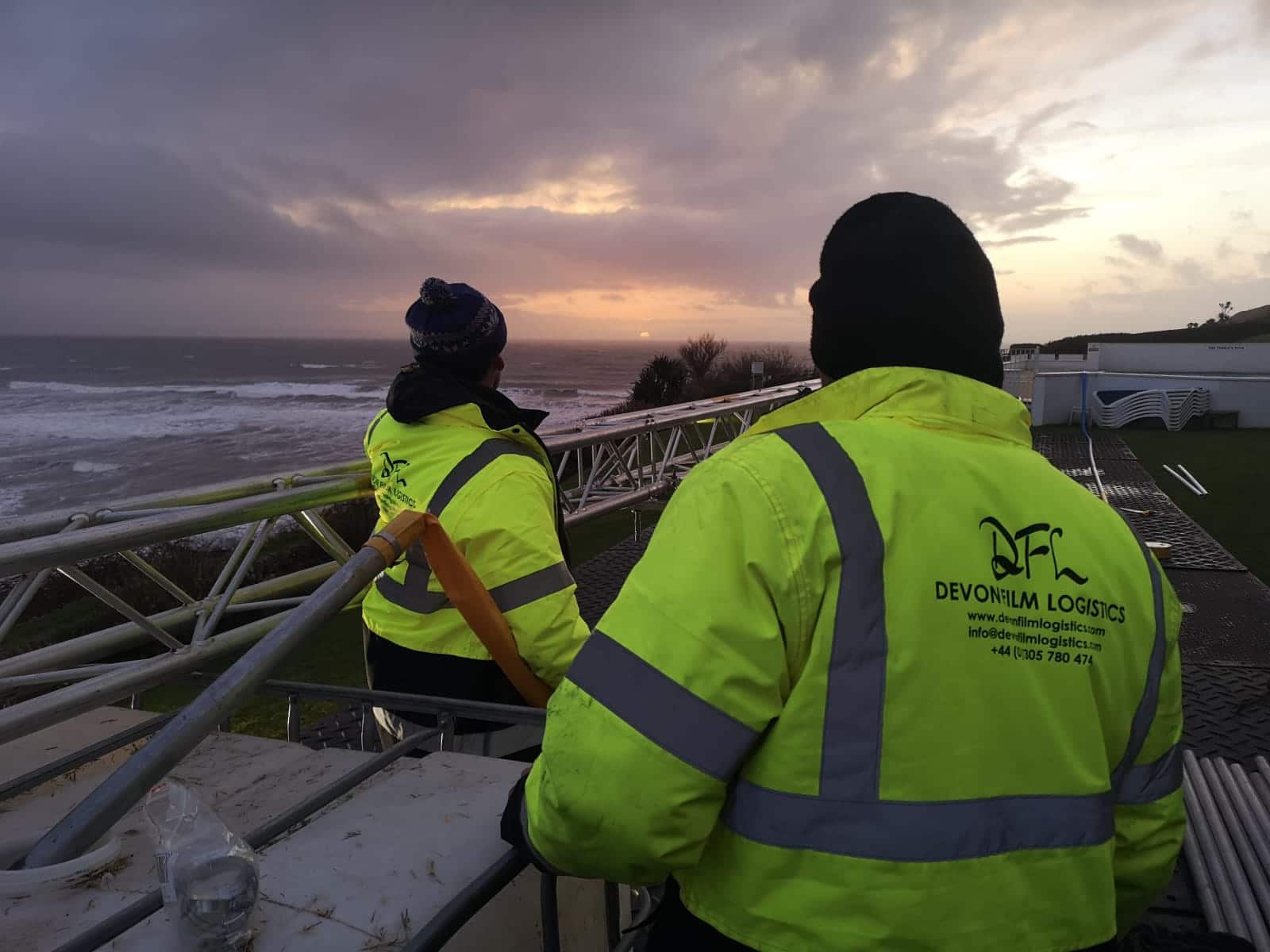 DFL crew overlooking a coastal production site at sunset
